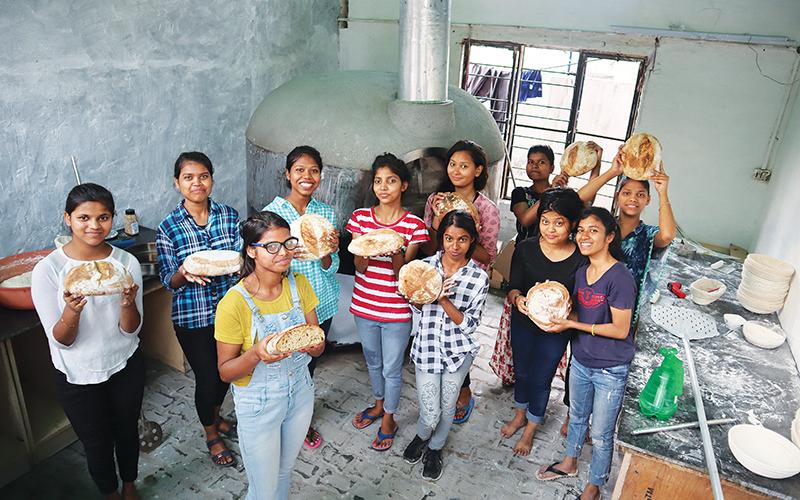 Neha, Pooja, Rajni, Jyoti, Mamta, Gayatri, Kajal, Kanchan, Tulsi, Angel and Taniya show off their freshly-baked bread after a class with Clarkesville bakery owner AJ White in India.