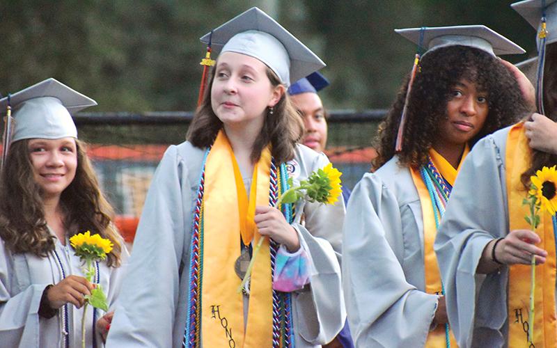 Habersham Central valedictorian Grace Wills and salutatorian Anea Harris prepare to walk on the field with their fellow graduates on Friday night.