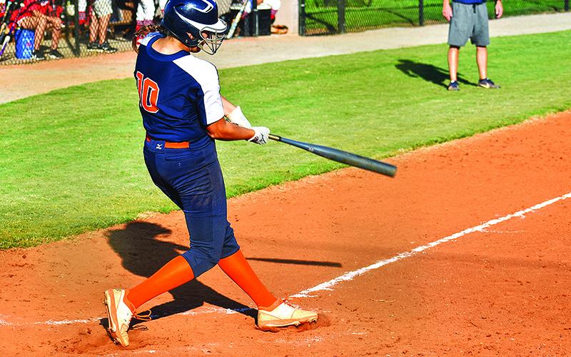 Kyla Quiles follows through on a single up the middle to drive in the game-tying run in the bottom of the seventh. Quiles also pitched five innings in relief and struck out seven Lady Indians. Below, Sadie Hawkins tracks a fly ball in Tuesday’s game against Stephens County.