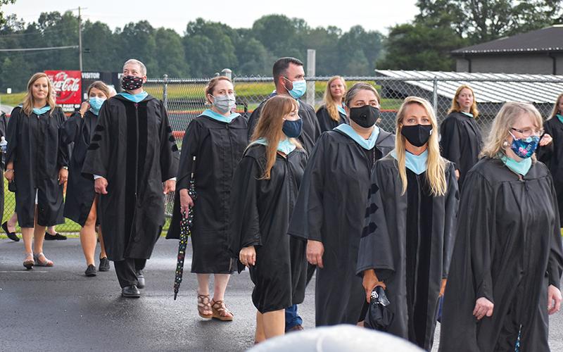 Teachers prepared to walk onto the field before graduation, many of whom opted to wear masks.