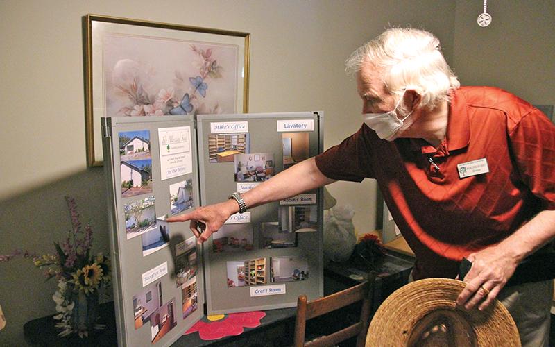 The Mustard Seed Director Michael Johns points to a collage of pictures from when their Cornelia office was purchased.