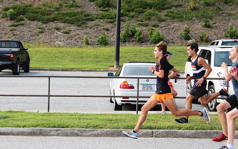 Andrew Kivett (running in front) leads Habersham Central’s cross country team in several different ways this season.