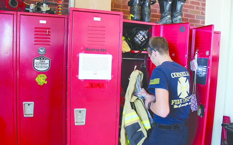 Cornelia firefighter Tristan Stephens goes through his locker during a recent shift. WoodmenLife’s fundraiser is set up to help the Cornelia Fire Department purchase a new emergency life raft and other equipment to be used for training in its new fire station.