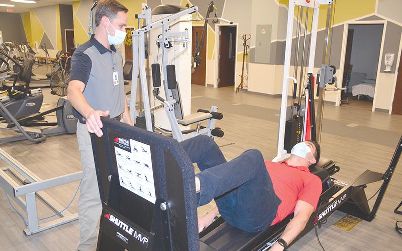 Habersham Medical Center rehab employees Jim McGahee (left) and Zachary Robertson demonstrate a new leg press machine that is part of the arsenal of physical therapy equipment at the brand new Rehabilitation & Orthopedics Complex.