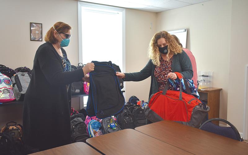 Renee Smagur, 4-H program assistant, organizes backpacks with Habersham DFCS County Director Cara Galloway.