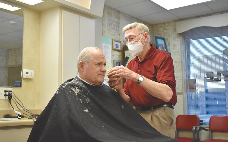 Jim Daniel works on a haircut Thursday morning for one of his longtime customers, Arthur Howard. Daniel has cut hair at his shop in Cornelia since 1961.