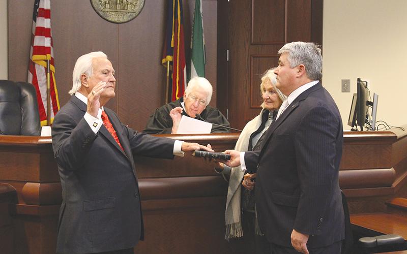 Bubba McDonald of Clarkesville (left) takes his oath of office as a Public Service Commissioner from Judge Joseph Booth (center) while his wife Shelley and son State Rep. Lauren McDonald III stand alongside him.