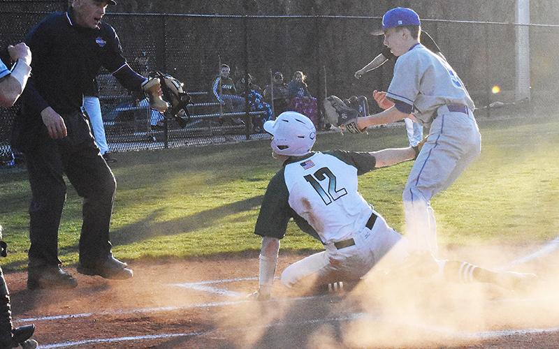 TFS catcher Chathan Clouatre safely slides into home after a passed ball during Wednesday night’s game against Riverside Military Academy.