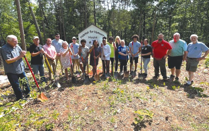 From left, Tom Gagnon, Ron Coker, Patrick Ledford, Kallan Williams, Nanette Baughman, Dan Nee, Enzo Combs, Tinisha Combs, Emyrie Combs, Lizzie Trimar, Marianne Longerbone and April Ferguson helped break ground for the Habitat for Humanity house in Demorest on Monday. BRIAN WELLMEIER/Staff