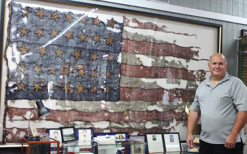 Bob Matis, owner of Civil War Corner Antiques in Dillard, owns a United States flag used in the Civil War in the Battle of Cold Harbor on June 3, 1864. It is displayed in his shop along with a display. The flag has 34 stars and two stripes are missing after being torn off in battle. MEGAN BROOME/The Clayton Tribune