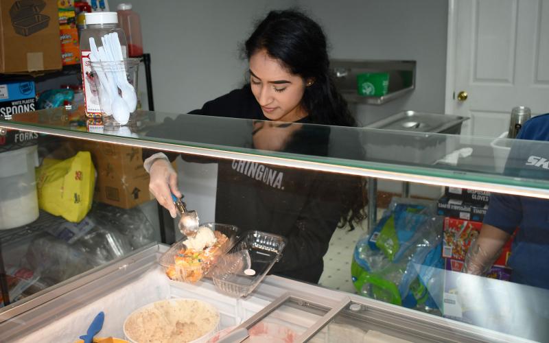 Yesenia Covarrubias serves up one of the many items from the menu of ‘antojitos,’ or Mexican street food. AMARIS E. RODRIGUEZ/Staff 