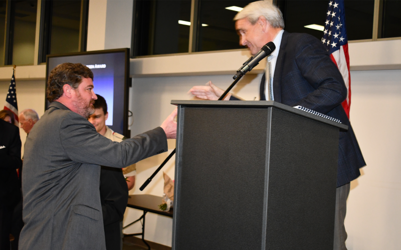 Former publisher of The Northeast Georgian Alan NeSmith (left) gets a handshake from presenter Charlie Fiveash as he is honored as a Distinguished Citizen. MATTHEW OSBORNE/Staff