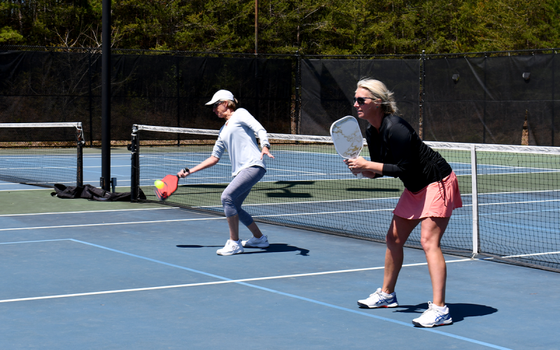 Denise Ralph (left) and Myrna Owen (right) serve back to the opposing side at the county’s soon-to-be resurfaced tennis courts. BRIAN WELLMEIER/Staff