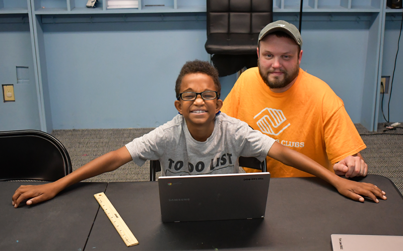 A student learns coding from a volunteer, one of many things the students learn after school and during the summer. ROWAN EDMONDS/Staff