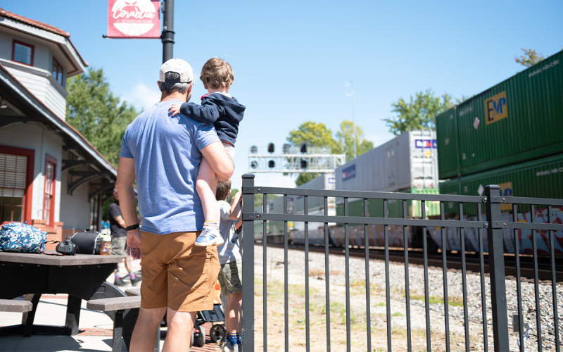 In typical Cornelia fashion, Johnny Dugan and his sons Walker and Jonah watch as the train speeds by during the 2022 Big Red Apple Festival. ZACH TAYLOR/Special