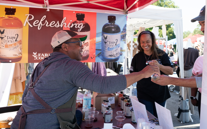 Founder of Farm 2 Cocktail, Carlton Chamblin (left), provides refreshing samples to Big Red Apple Festival goers Shanda and Christopher Vickery (right). ZACH TAYLOR/Special
