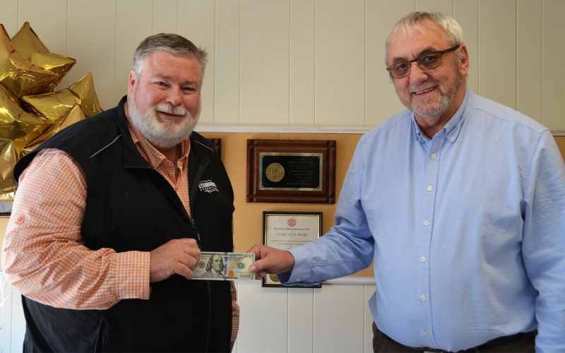 Richard Clark, left, accepts $100 from Wayne Knuckles, White County News  interim publisher, for his photograph of colorful leaves. Clark’s photo was chosen for the cover of the fall 2022 edition of The Mountain Traveler. LINDA ERBELE/White County News