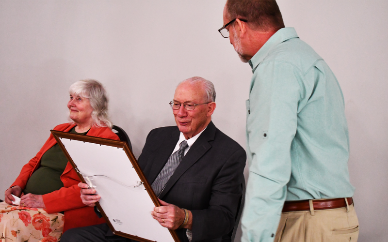 Dr. Bob Wiley admires a proclamation given to him and his wife Mary Ann (left) at a Habersham United Believers event on Thursday. The Wileys were presented the gift by Jason Blackburn. MATTHEW OSBORNE/Staff