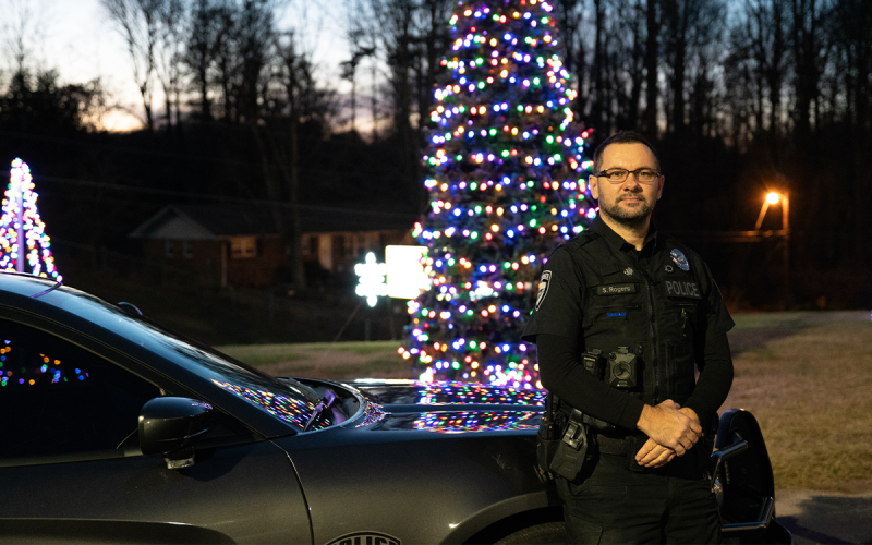 Alto Police Officer Sean Rogers stands in front of the Alto City Hall Christmas tree at the canceled tree lighting event on Thursday. ZACH TAYLOR/Special