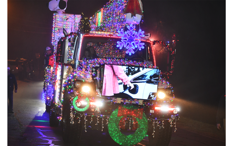 Rarely is there a more brightly- colored float in the Christmas parade than the one from Habersham EMC, which included a working  television on the front grill.  MATTHEW OSBORNE/Staff