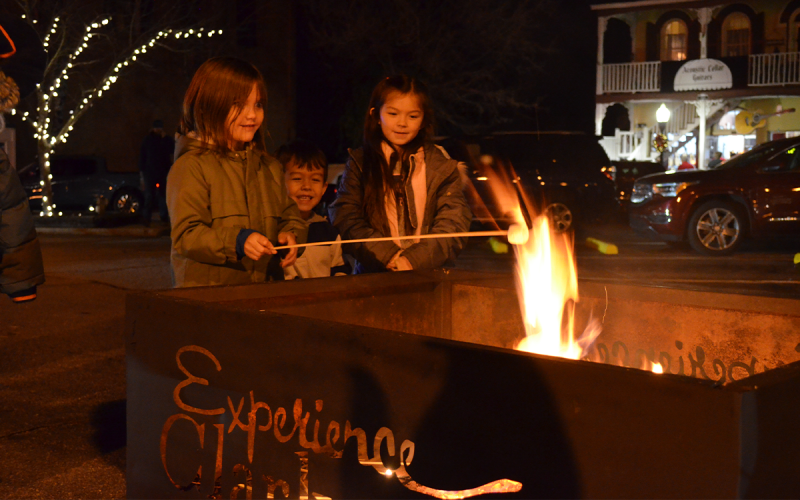 Claire Lee, Alex Weems and Avery Weems enjoy the chance to roast marshmallows at Clarkesville’s Downtown Christmas on Dec. 2. SAMANTHA SINCLAIR/CNI News Service