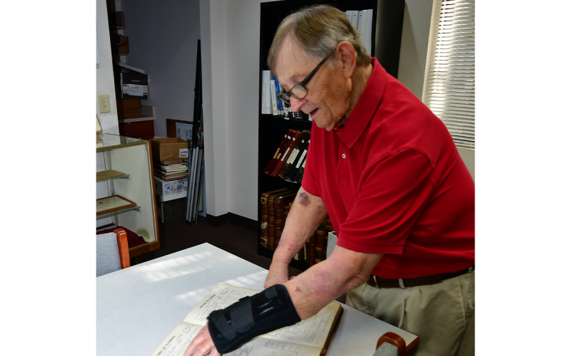 Bill Raper looks at a record of funerals in the genealogy room at the Clarkesville Library. Birth, marriage and death records are key components of genealogical research. KIMBERLY BROWN/Staff