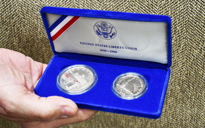 President Marshall Criser shows United States Liberty Coins, left dated 1886 and right dated 1986. JOHN DILLS/Staff