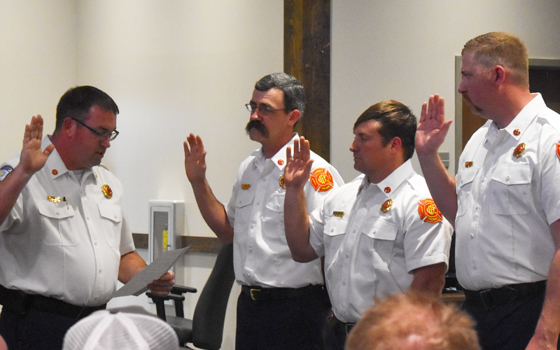 Division Chief and Fire Marshal Josh Hazle leads Capt. Dustin Henson, Capt. Drake Meister and Capt. Lee Humphrys in the oath during the pinning ceremony. EMMA MARTI/Staff