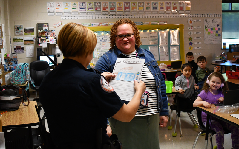 School Resource Officer Evaleez Gonzalez happily accepts a student’s drawing from Mrs. Kristy Hill’s classroom at Fairview Elementary. JOHN DILLS/Staff
