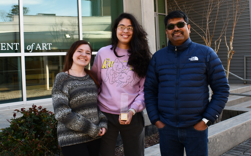 From left, Lily Philips, Nicole Salazar and Professor Santanu Majumdar show off the first place prize for the Student Startup Competition. JOHN DILLS/Staff