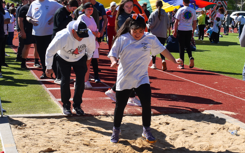 Ninth Grade Academy athlete Fatima Guzman lands in the sand as she participates in the standing long jump during Monday’s Special  Olympics at Raider Stadium. EMMA MARTI/Staff