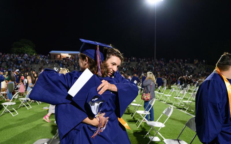 Habersham Central seniors Dan Griswold and Cody Thomas hug while parents and siblings rush the field to find their graduates. ZACH TAYLOR/Special