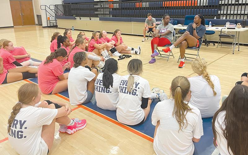 Volleyball professionals Lauren Ford and Santita Ebangwese (seated at right) impart wisdom to the campers.