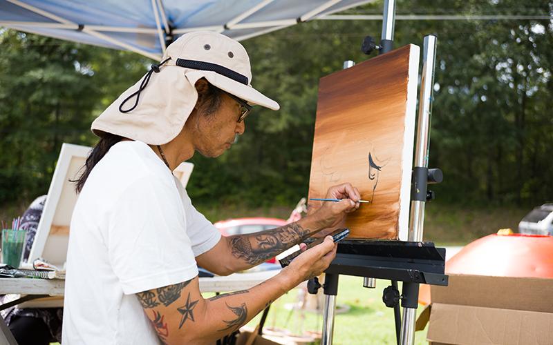 Son Nguyen paints a realistic rendition of a water buffalo in the sunset. ZACH TAYLOR/Special
