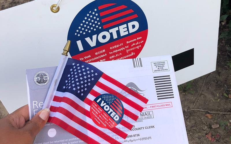 A photo of a voting sticker with a mail advertisement. UNSPLASH PHOTO