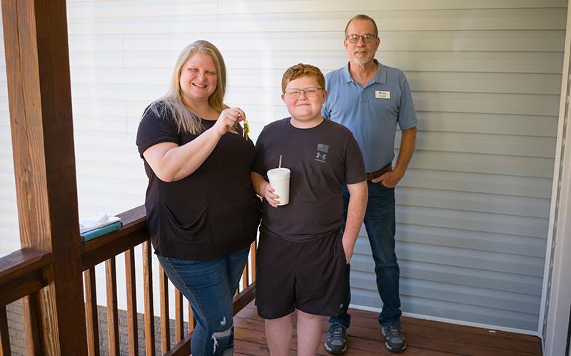 Jennifer Payne and her son Caleb stand with Habitat for Humanity Board President Rex Wade on the front porch of her new home. ZACH TAYLOR/Special