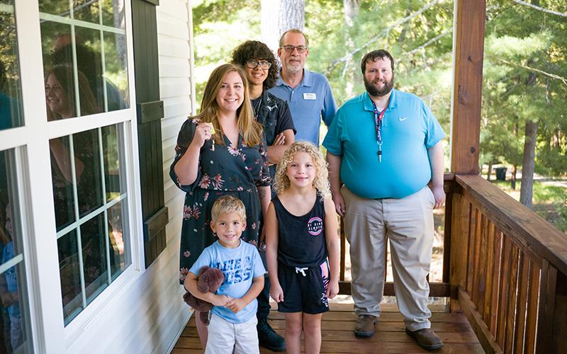 Alicia Murphy stands proudly on the front porch of her new home with Elijha, Ava, Kenneth, Habitat for Humanity Board President Rex Wade, and Mathew Henson (right). ZACH TAYLOR/Special