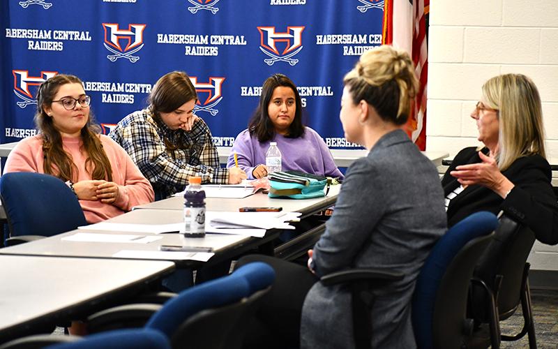 From left, Habersham Central High School students Sarah Wheeler, Brook Scherer, and McKenzie Smith listen and take notes while Attorneys Rebecca James, left, and Suzanne Boykin, right, teach them about objections. JULIANNE AKERS/Staff