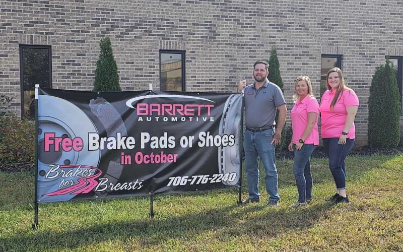 From left, Service Advisor Chris Howland, Owner Nicole Barrett, and Service Advisor Jessica Barrett stand with the Brakes for Breasts sign at Barrett Automotive. SUBMITTED