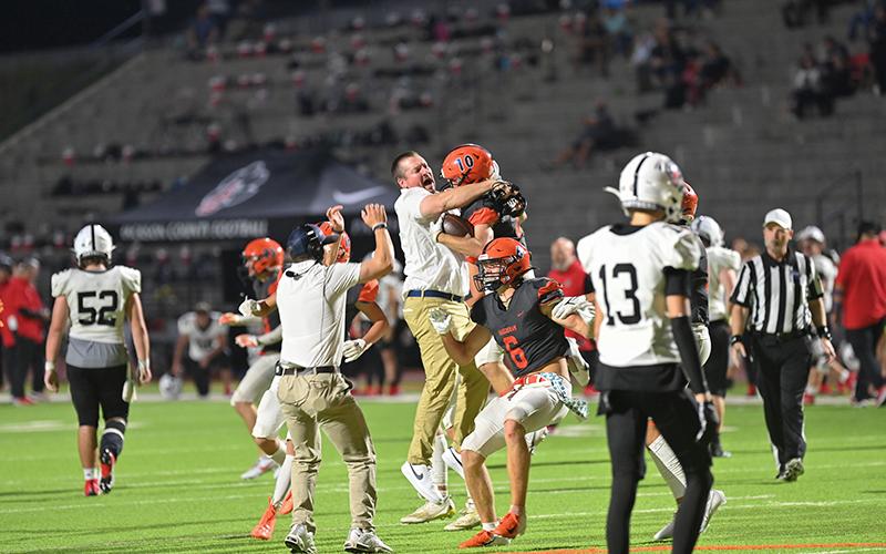 Habersham Central assistant coach Brandon Worley embraces Hayden Gailey (10) in the pandemonium following Gailey’s game clinching interception in double overtime on Friday night against Jackson County. TOM ASKEW/Special