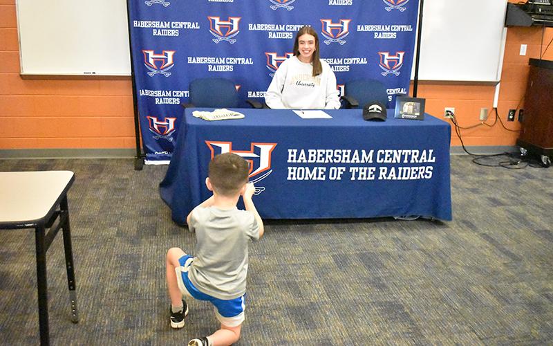 Brooks Herrin works on his photography skills Wednesday, looking for the perfect shot of Habersham Central’s Kyia Barrett at her signing ceremony for Anderson University basketball on Wednesday. MATTHEW OSBORNE/Staff