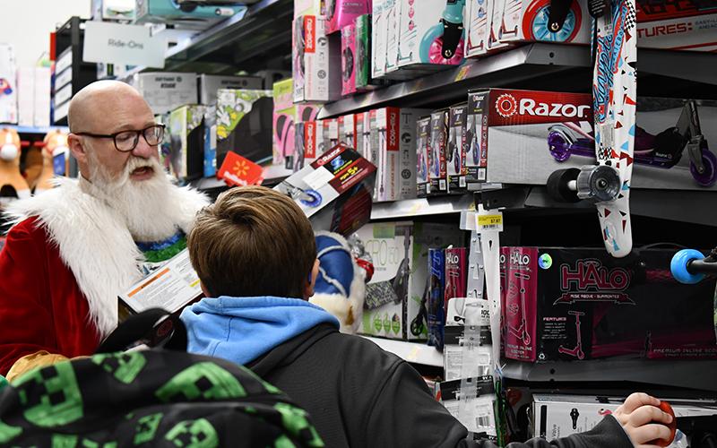 Santa helps Adam Norton pick out the perfect razor scooter at Baldwin’s Shop with a Hero event, not without reminding Adam he needed a helmet to go with his new ride. JULIANNE AKERS/Staff