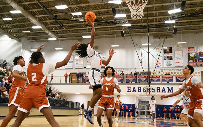 Habersham Central’s Enzo Combs floats to the rim for two points for the Raiders against Lanier on Tuesday night over the Longhorns’ Amari Morgan (5). ZACH TAYLOR/Special