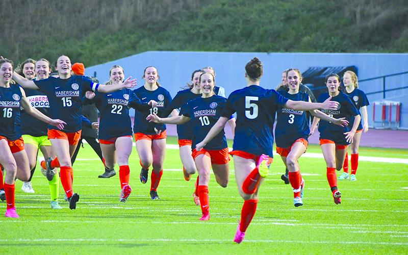 The Lady Raiders run toward Piper Turner (5) after she converted the game-winning penalty kick against North Forsyth on Tuesday night.  LANG STOREY/Staff