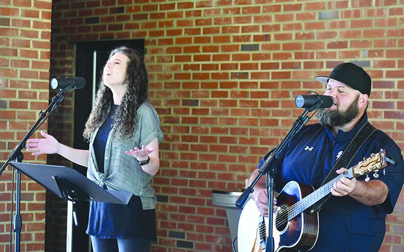 Britney Sanders, left, and Chris Smith, with Purpose Church at Bethel Temple perform worship songs at Demorest’s gathering at Demorest Springs Park. JULIANNE AKERS/Staff