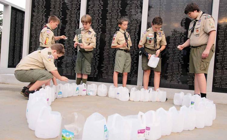 Boy Scouts Troop 106 of Homer and Troop 5 of Clarkesville help with the candlelight vigil at the Habersham County Veterans Wall of Honor, Cornelia. The ceremony paid respects to the victims of the 9/11 terrorist attacks. Shown, from left, are Samuel Hattaway, Matthew Owens, Caleb Crump, Mitchell McGahee, Joseph McGahee and Cameron Mote. (Photo/ERIC PEREIRA)