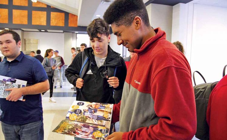 Habersham Central High School (HCHS) seniors Brett Browner, right, and Jose Bravo, center, check out a brochure from Georgia Southern University at the annual College PROBE Fair. About 50 colleges and universities visited HCHS Thursday to connect with students about post-secondary education opportunities. (Photo/ERIC PEREIRA)