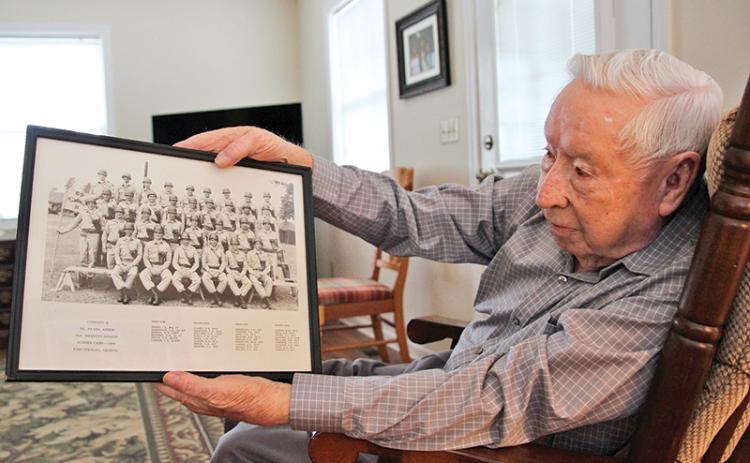 Donald Tench shows a photo from his Army days. Tench, 90, served 38 years in the Army and reserves. He continues to participate in military funerals which he has done for over 60 years. 