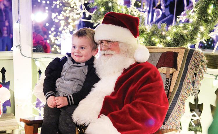 Jameson Baker, 3, of Clarkesville gets a photo with Saint Nick at A Downtown Clarkesville Christmas.