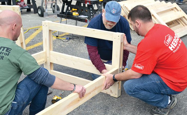 Volunteers Jason Grooms (left), Skip Sevier and Jeremy Gattis assemble the first of 20 bunk beds built Saturday by Lowe’s volunteers in conjunction with the charity Sleep in Heavenly Peace.
